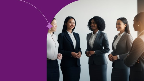 woman coworkers standing chatting togther in an office smiling