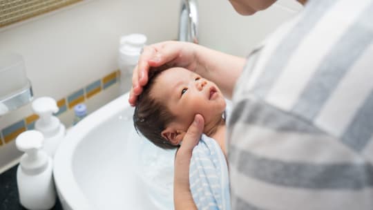 mother bathing newborn