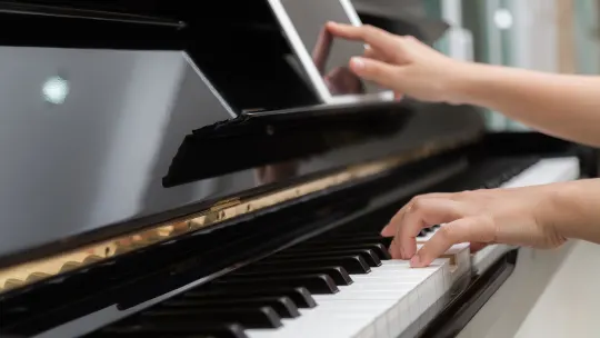 Woman hand use tablet and playing piano music