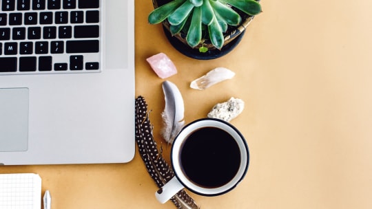 stylish laptop phone and notebook and coffee with feathers crystals