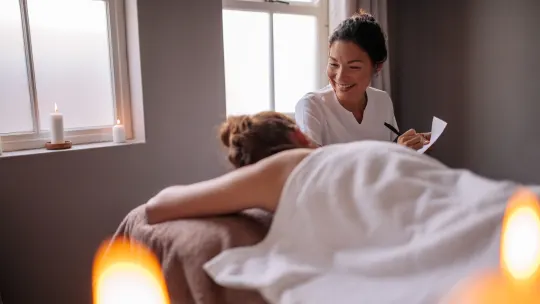 massage therapist and student giving client a massage