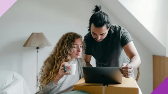 Two people at a computer, illustrating how to set up a joint bank account online