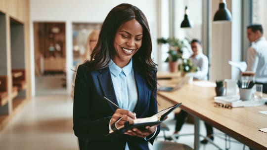 professional woman taking notes in a notepad