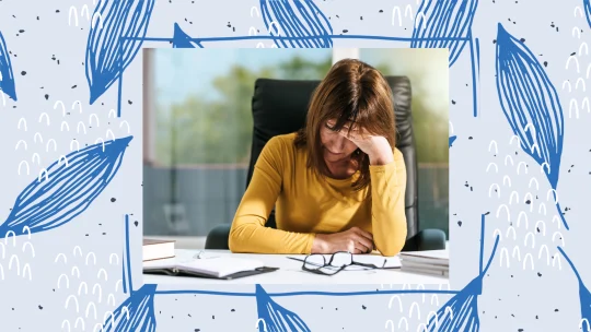 woman sitting at a desk with her face in her hands