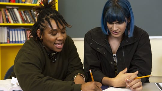 two people sitting and getting a tutoring session