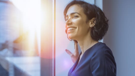 successful woman looking out window