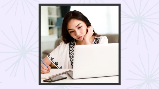 a woman stressed looking at a laptop.