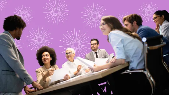 Coworkers sitting at table smiling.