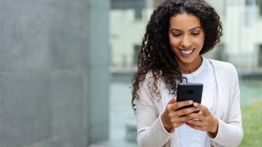 woman checking her phone, smiling