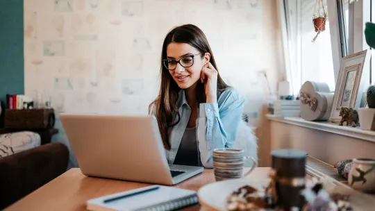 A woman types on a laptop.