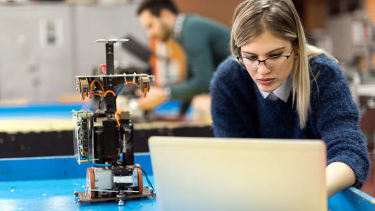 A woman in a lab works on a computer