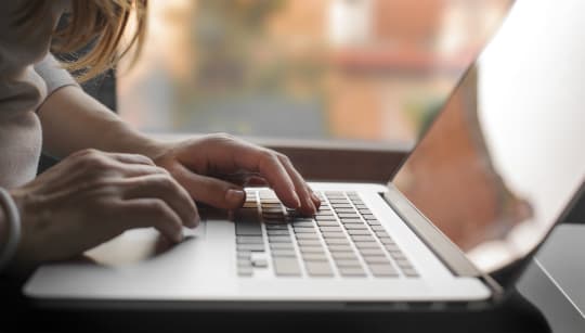 woman writing on computer