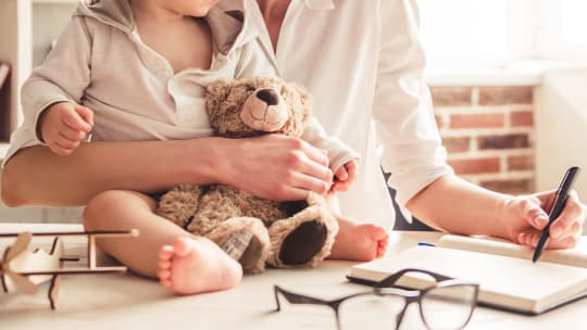 Woman writing letter with child