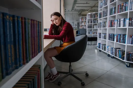 woman procrastinating at the library