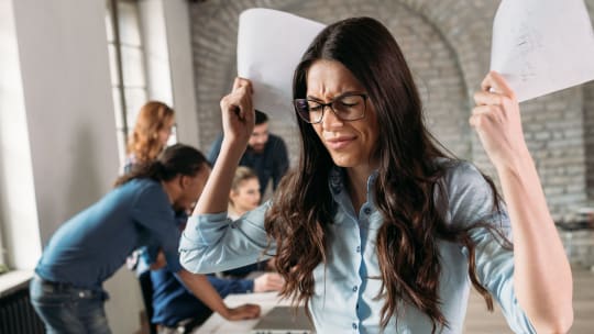 photp of angry overworked businesswoman in office