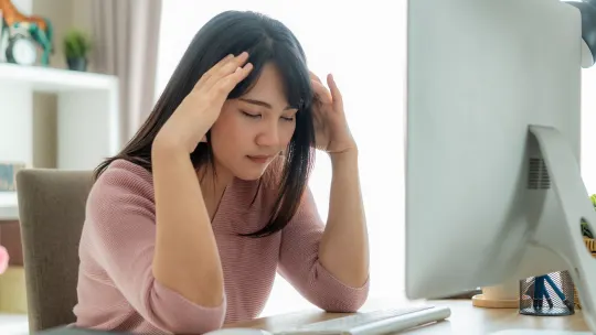 A woman types on her laptop