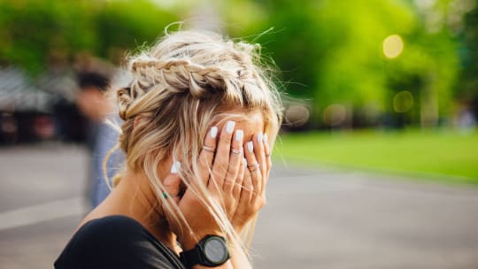 woman covering face with hands