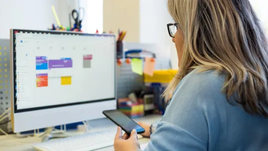 woman organizing phone and desktop calendar