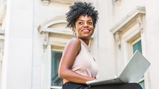 woman sitting outside using a laptop