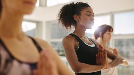A woman closes her eyes while doing yoga