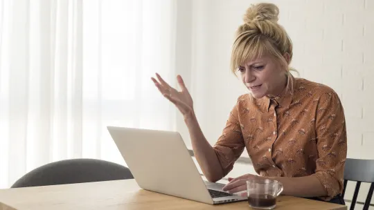 Frustrated woman looking at laptop