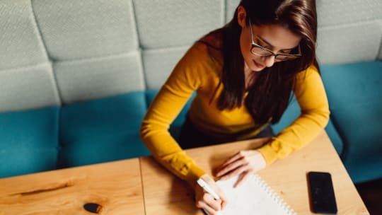 woman writing mission statement at desk
