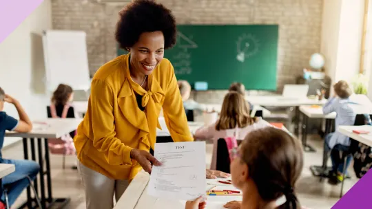 A female teacher in a classroom interacting with a young student to illustrate what a pink collar job is. 