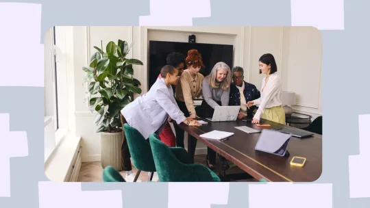 a group of women pointing at a laptop