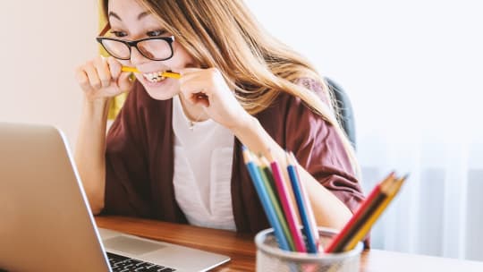 woman chewing pencil at work 