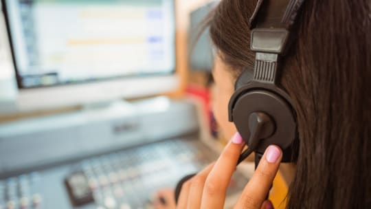 music curator mixing audio while listening to headphones