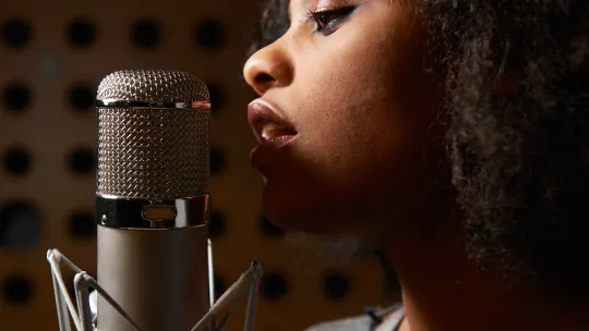 singer at a microphone in a recording studio