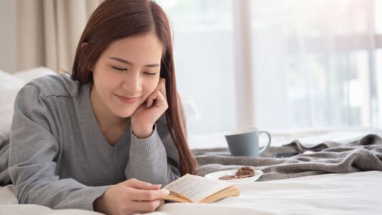 woman reading a book in bed