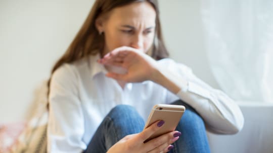 distressed woman looking at her phone