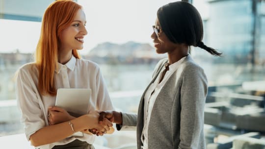 two women talking in an office 
