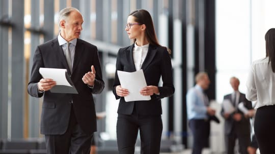A man and a woman walking in an office