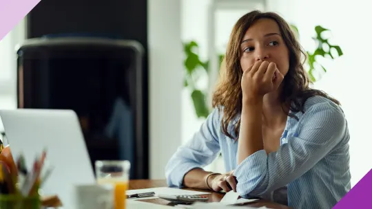 Woman staring out window at an office to illustrate the importance of learnings the signs you should quit your job and move on.