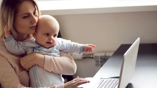 Woman on laptop with baby