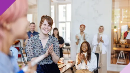 Photo of a meeting with people applauding, illustrating the positive impact of daily habits of successful people on both personal and professional lives.