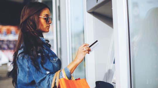 woman putting coins in a piggy bank