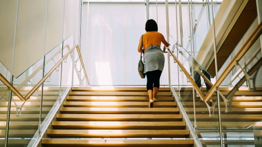 professional walking up the stairs at work