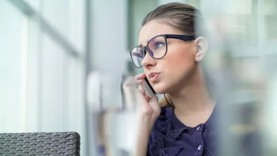 woman sitting on the couch holding her phone
