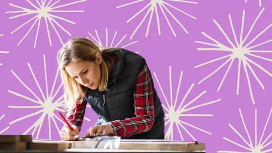 A woman bent over and working at a desk.