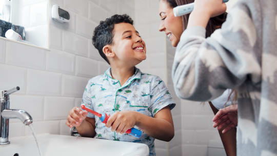 Mom with son brushing teeth