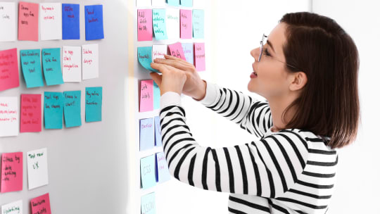 woman posting sticky notes on a wall