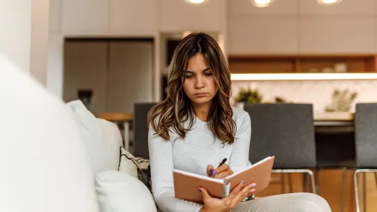 Confused woman writing