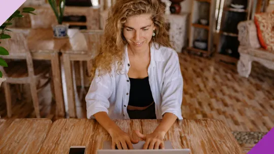 A woman at home typing on a laptop to illustrate how learning the differences between independent contractor vs employee is important to figure out what's best for your career