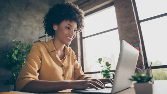 Woman typing on computer, smiling