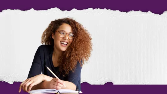 woman writing while working on laptop