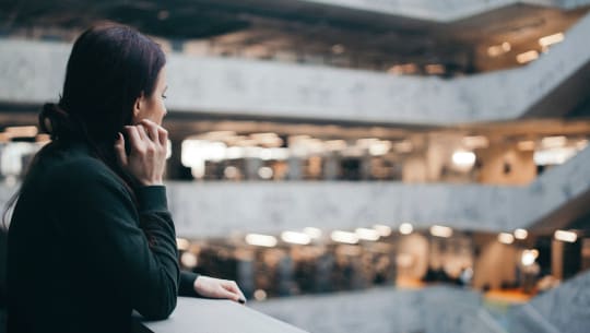 A woman stands by herself looking into the distance