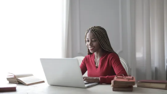 woman typing on a laptop at home